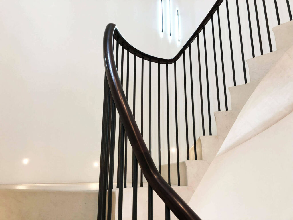Rising twisting natural wooden staircase handrail in American Black Walnut by PT Handrails at Clive Durose Staircase Project @ Cadogan Square, Chelsea