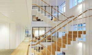 Savile Road commercial staircase natural wood handrail multi floor view by PT Handrails, by Clive Durose