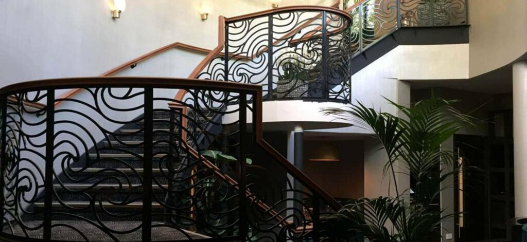 Sweeping staircase with alchoves in metal and wood at Grantely Hall Hotel, Ripon, by PT Handrails @ Clive Durose